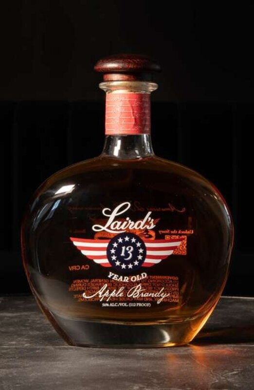 The screen-printed, hand-numbered decanter resting on dark stone